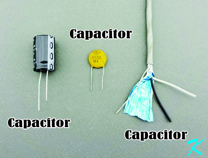 If a capacitor is two conductors separated by an insulator, then two wires inside a cable, each one insulated, makes up a capacitor. A shield increases this capacitance. I've made capacitors by twisting two insulated wires together, and then I measured the capacitance.